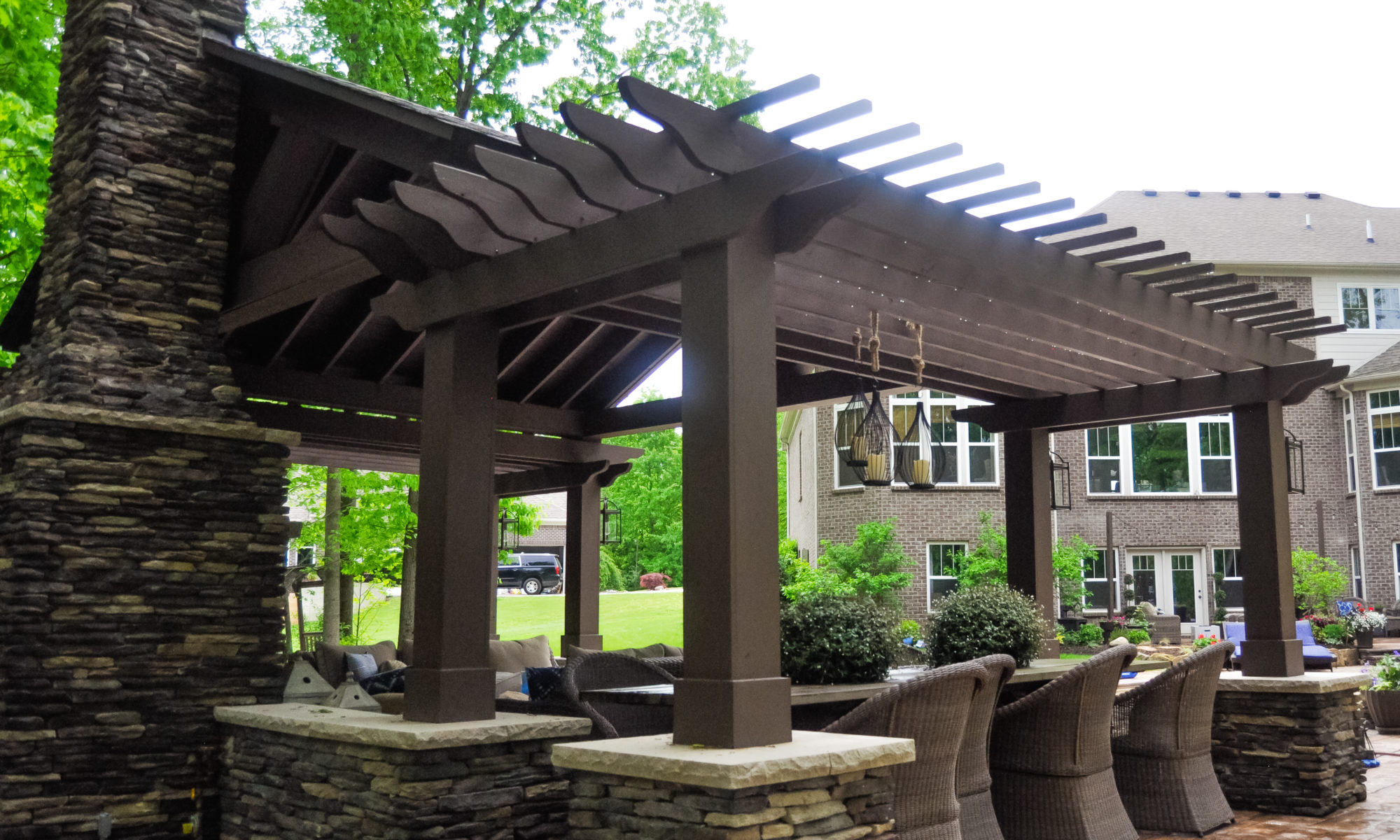 Precision Outdoors Avon patio & structure specialty built a-frame textured fireplace chimney pergola inspired structure decor additional seating raised sundeck tanning relaxation stamped concrete patio wrap around seating wall aesthetic style stone steps outdoor elements Avon indiana dream backyard pool