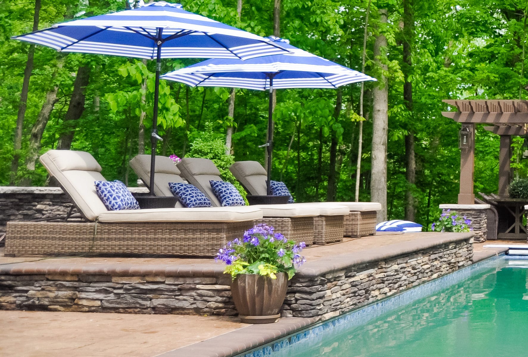 Precision Outdoors Avon patio & structure specialty built a-frame textured fireplace chimney pergola inspired structure decor additional seating raised sundeck tanning relaxation stamped concrete patio wrap around seating wall aesthetic style stone steps outdoor elements Avon indiana dream backyard pool
