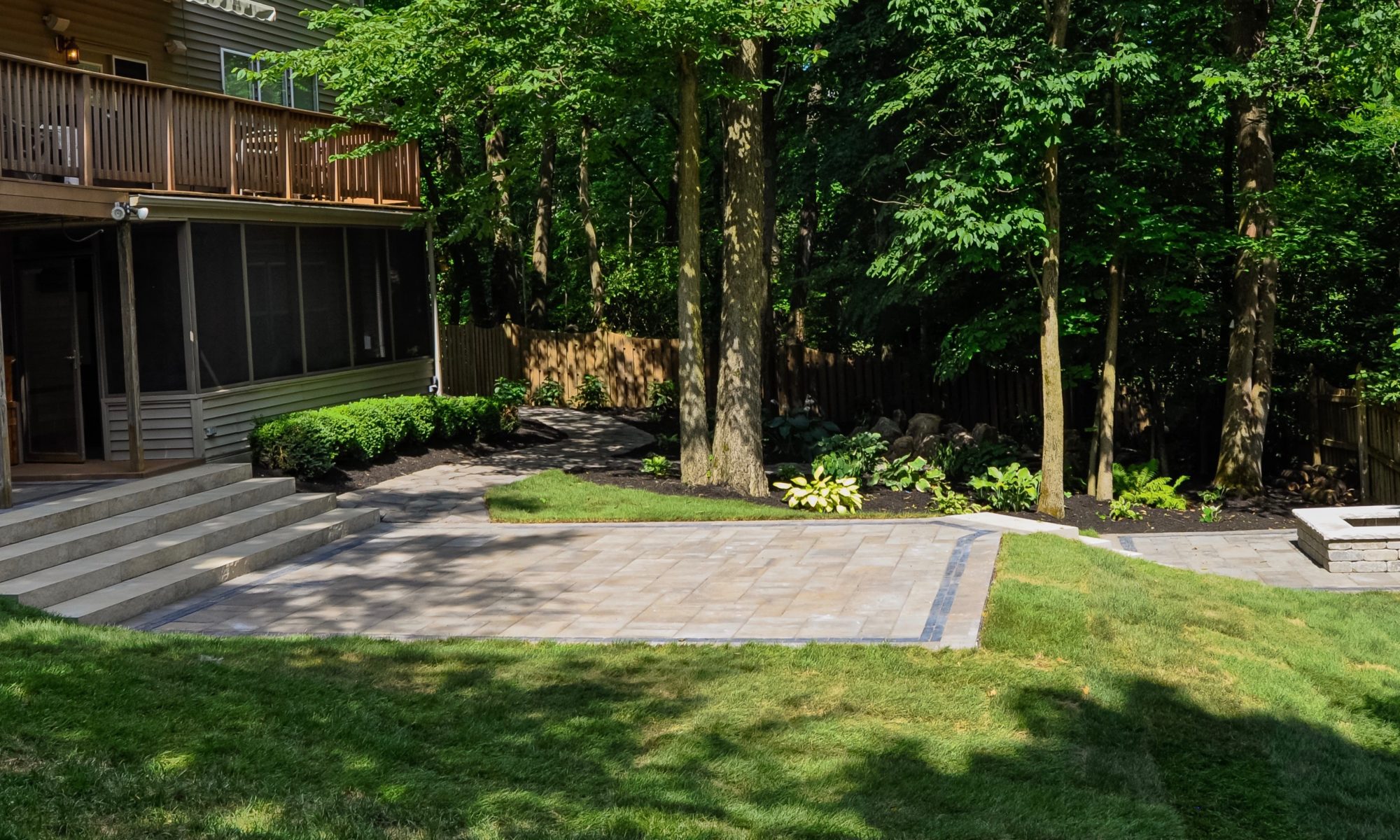 Precision Outdoors Fishers Paver Patio yard encompassing paver patio belgard lafitt material cotswald mist charcoal trim block firepit fire pit paved space quaint stairs porch bridge landing step landscaping mulching fishers indiana