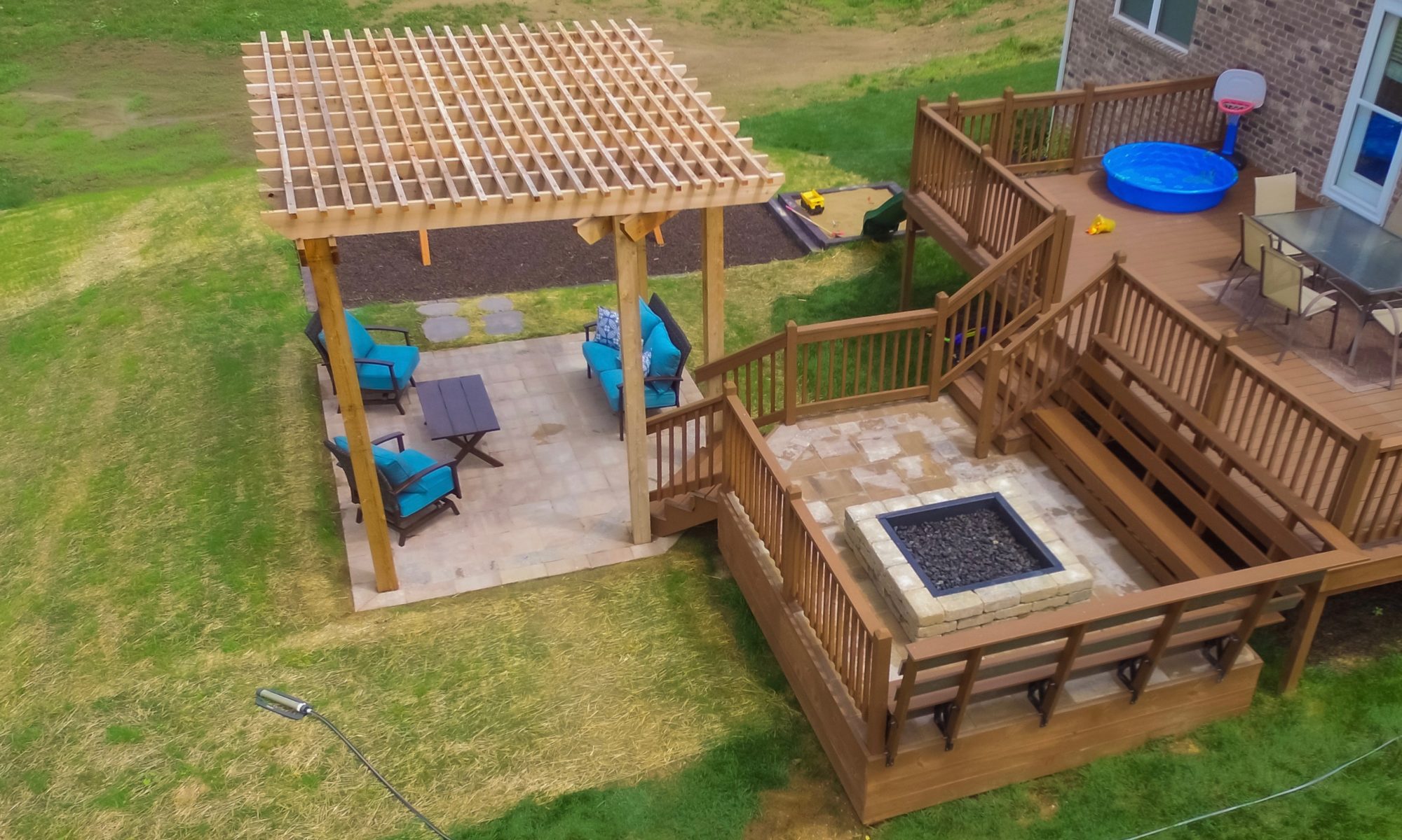 Precision Outdoors Fishers Pergola & Firepit cedar pergola structure firm paver patio beggar lafitt rustic slab Danville beige color accents wrap around firepit bench seating kids play area slide built in built-in deck sandbox play pad surrounding swing set area fishers indiana playground