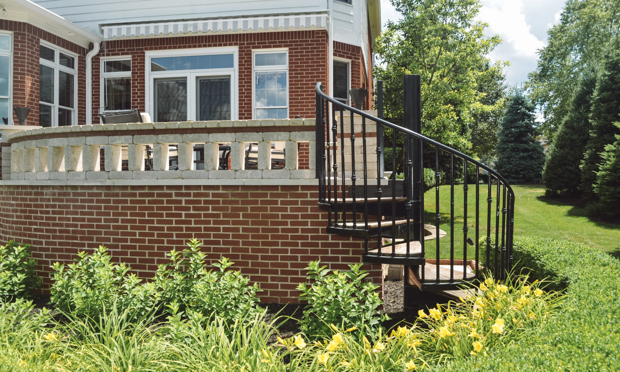 Precision Outdoors English Garden Overlook spiral stairs custom railing dining seating hosting custom patio brick retaining wall greenwood indiana patio