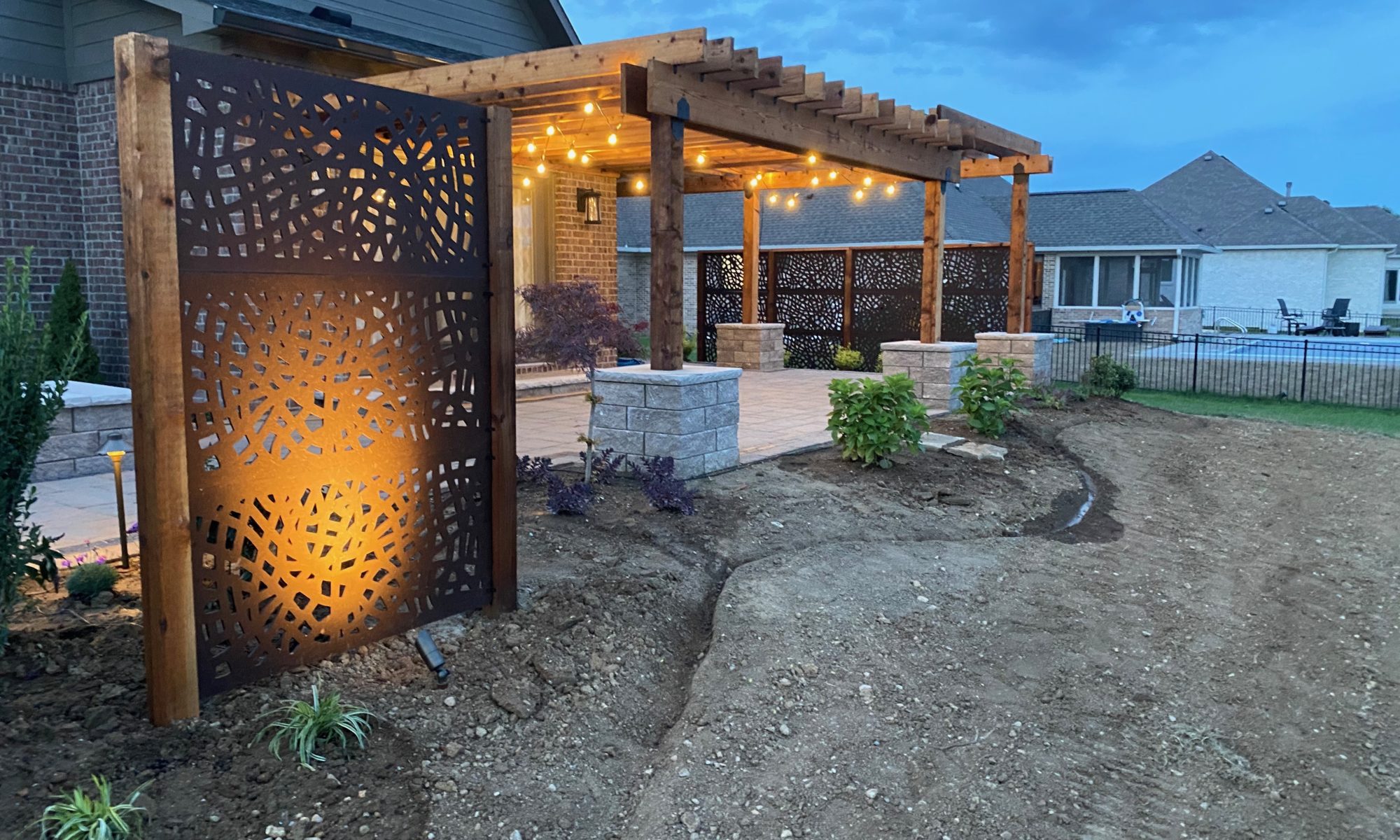 Kensington Oasis precision outdoors greenwood indiana landscaping pergola firepit paver patio lights night day decoratio swing construction daybed install