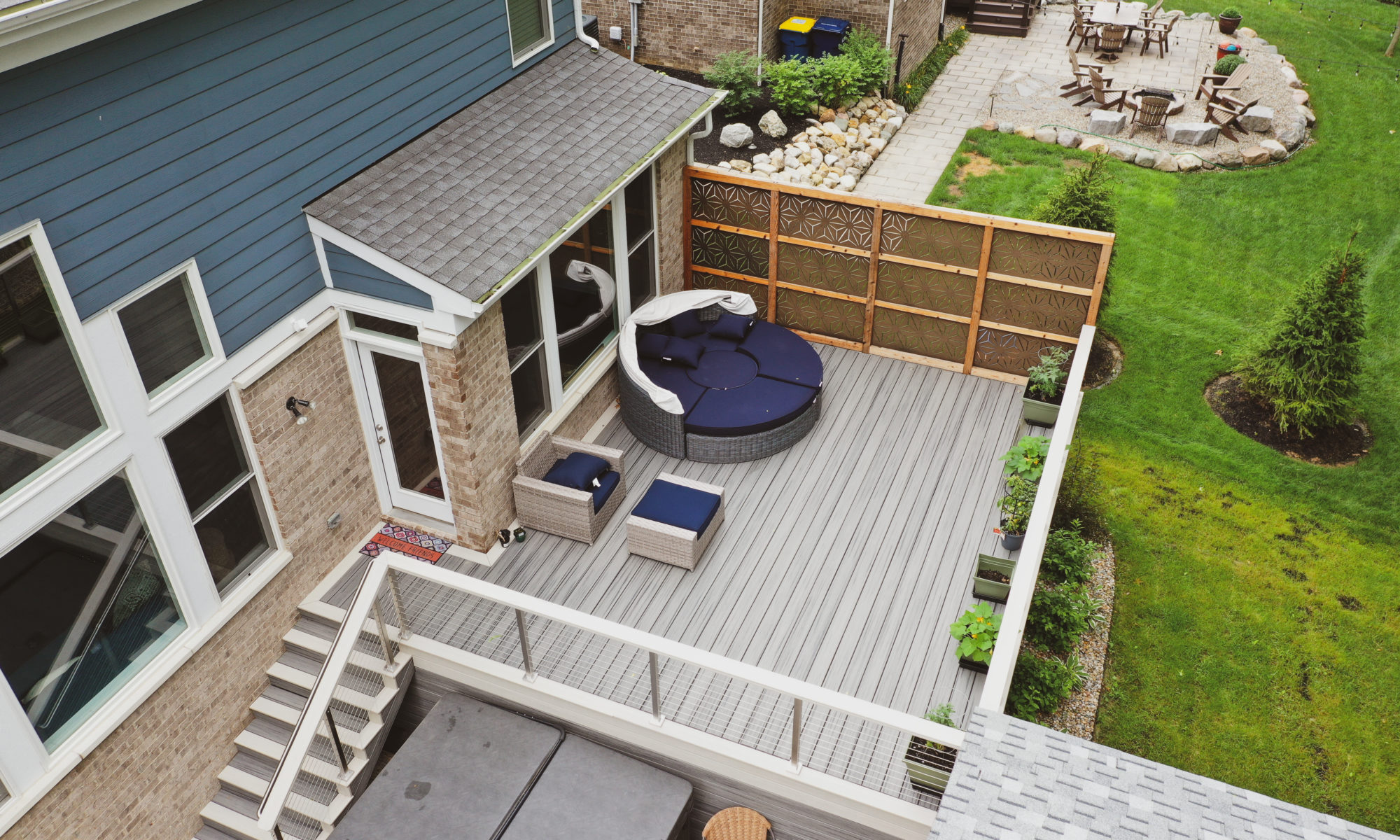 Gable Roof Structure Wood Burning Fireplace with gas fire log starter Outdoor Living by Belgard Noon tile patio Raised Deck Modern cable railing Privacy screens