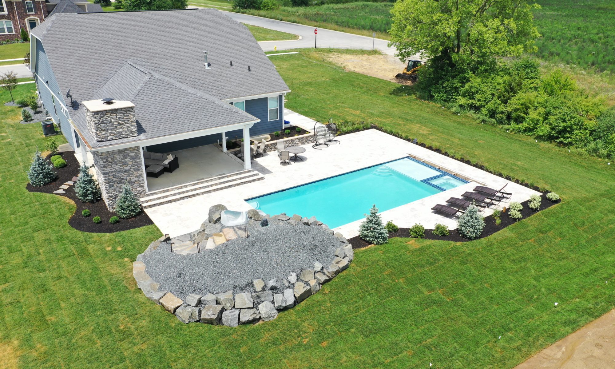 poolside pavillion paver patio pool fire fireplace stairs cover gray grey tanning deck graven plants trees flowers black
