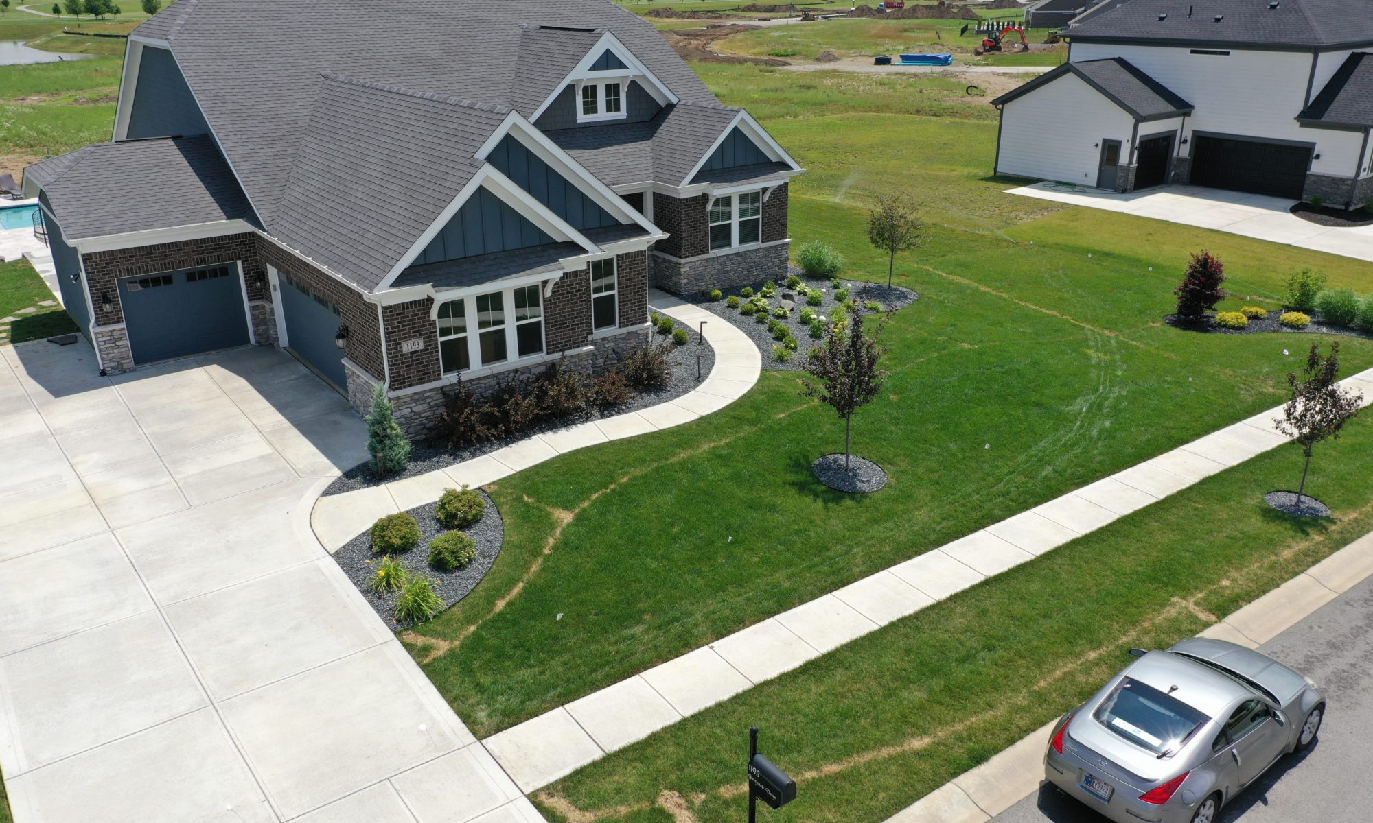 poolside pavillion paver patio pool fire fireplace stairs cover gray grey tanning deck graven plants trees flowers black