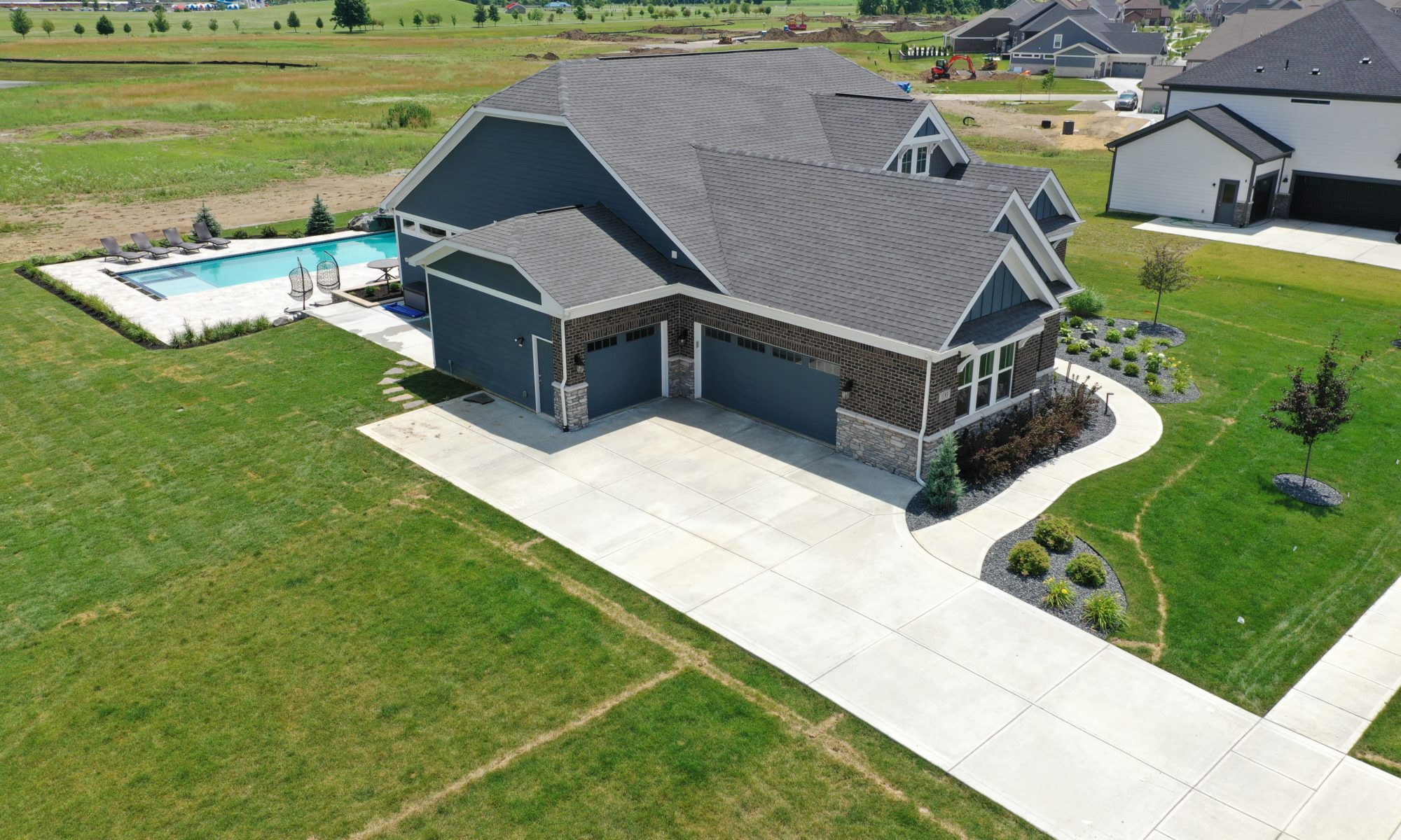 poolside pavillion paver patio pool fire fireplace stairs cover gray grey tanning deck graven plants trees flowers black