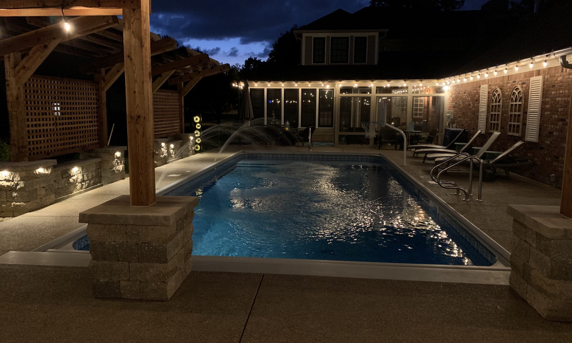 Precision Outdoors cannon cabana nights completed project night night time pool life fire table fire pit pool deck pergola outdoor kitchen timber structures retaining wall sun screens privacy screens outdoor dining entertaining space Greenwood Indiana