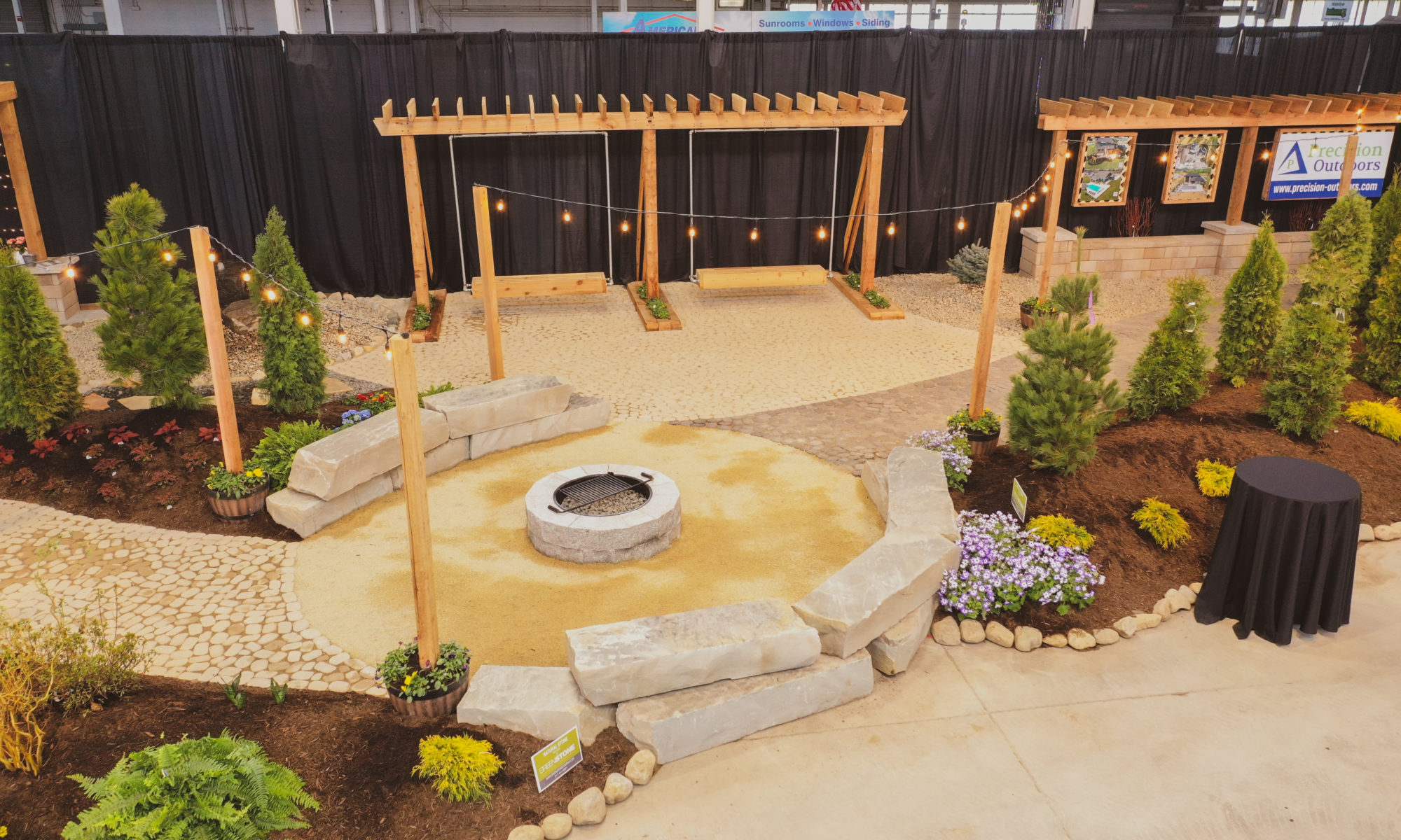 indiana indianapolis flower and patio show 2022 pergola fire pit swing swings lighting landscaping custom bubbling boulder water feature fire pit modern pergola outdoor grill island arbors custom swings landscaping precision outdoors