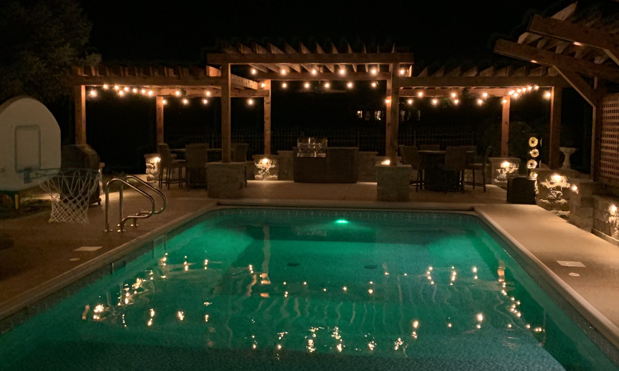 Precision Outdoors cannon cabana nights completed project night night time pool life fire table fire pit pool deck pergola outdoor kitchen timber structures retaining wall sun screens privacy screens outdoor dining entertaining space Greenwood Indiana