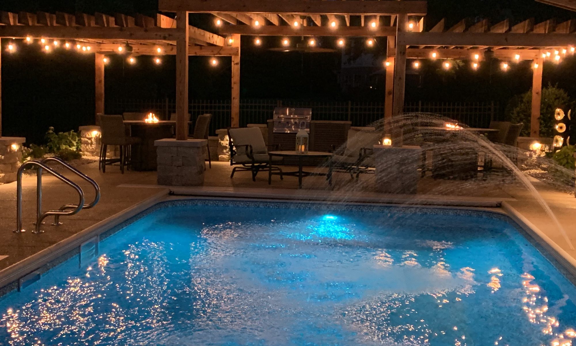 Precision Outdoors cannon cabana nights completed project night night time pool life fire table fire pit pool deck pergola outdoor kitchen timber structures retaining wall sun screens privacy screens outdoor dining entertaining space Greenwood Indiana