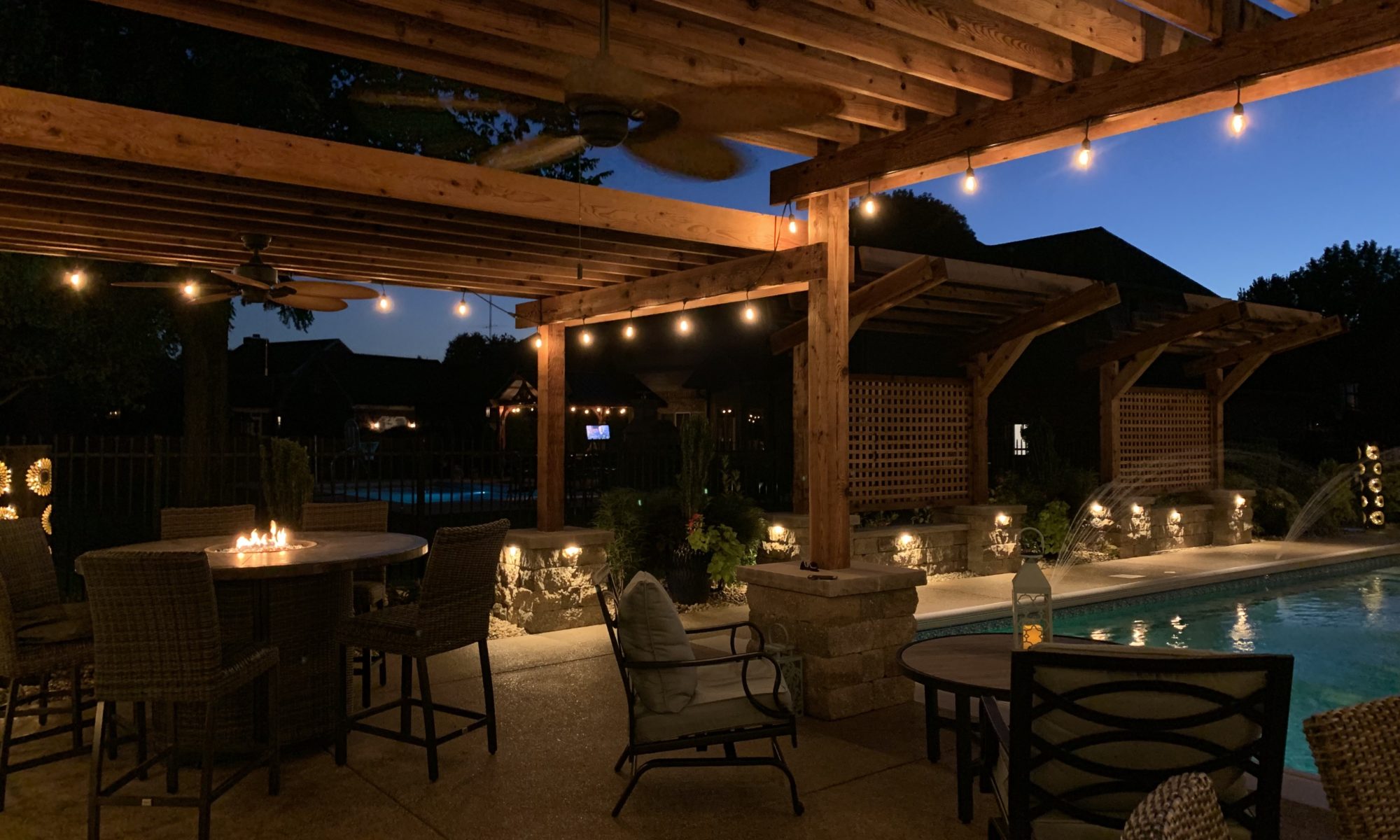 Precision Outdoors cannon cabana nights completed project night night time pool life fire table fire pit pool deck pergola outdoor kitchen timber structures retaining wall sun screens privacy screens outdoor dining entertaining space Greenwood Indiana