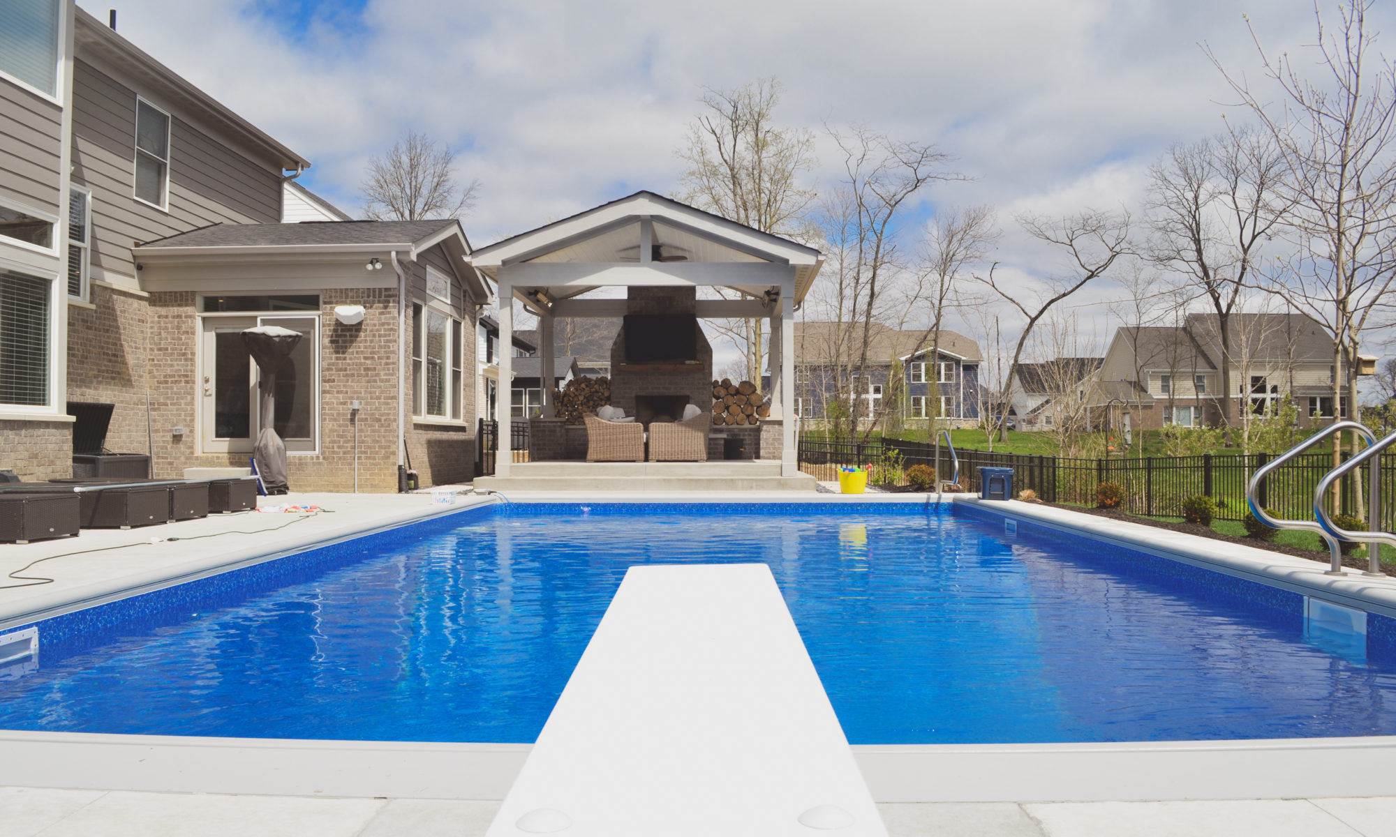 Precision Outdoors poolside at thorp creek gable roof structure fireplace fire wood storage concrete patio landscaping pool backyard summer entertaining outdoor fan heater rest and relaxation indianapolis indiana