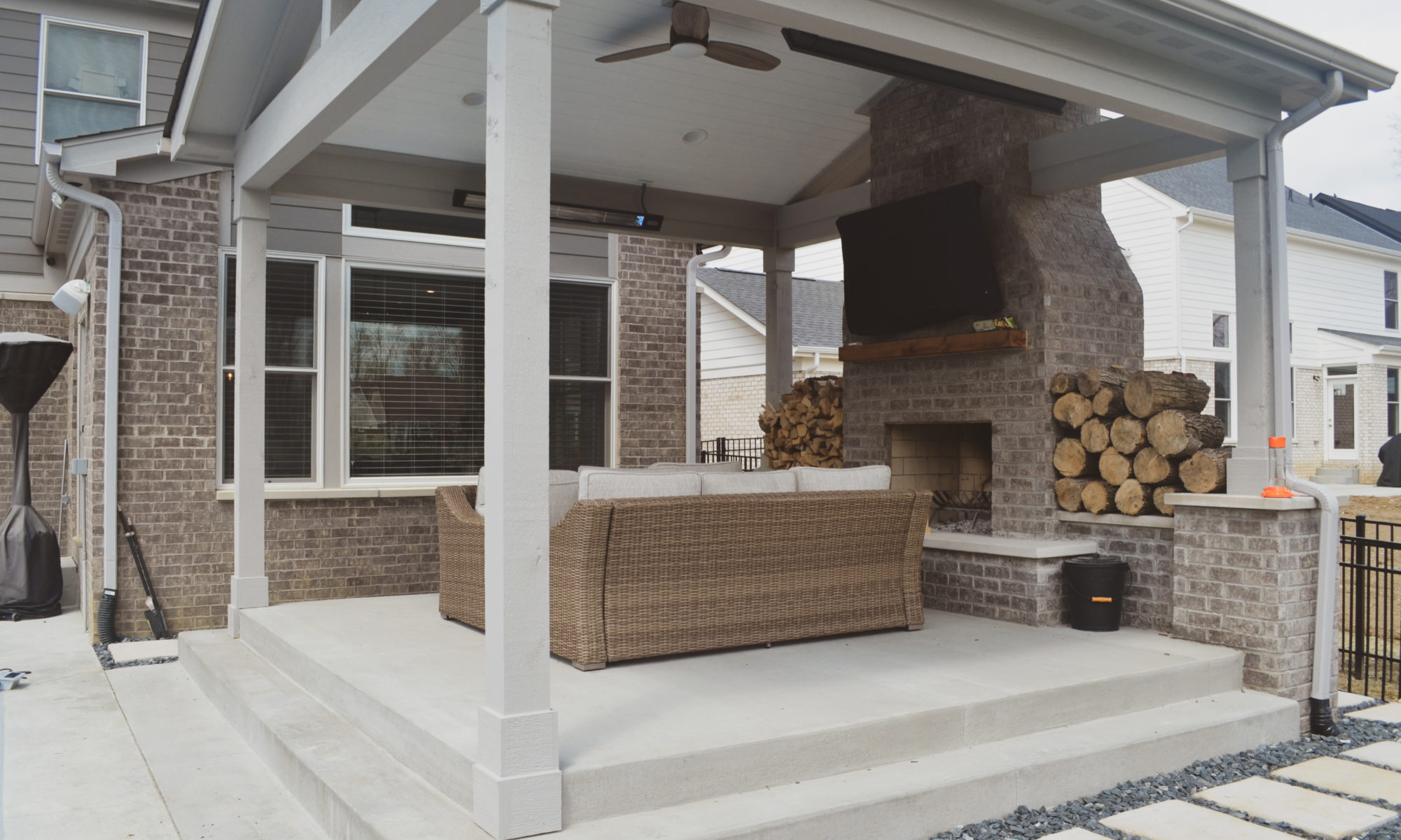 Precision Outdoors poolside at thorp creek gable roof structure fireplace fire wood storage concrete patio landscaping pool backyard summer entertaining outdoor fan heater rest and relaxation indianapolis indiana