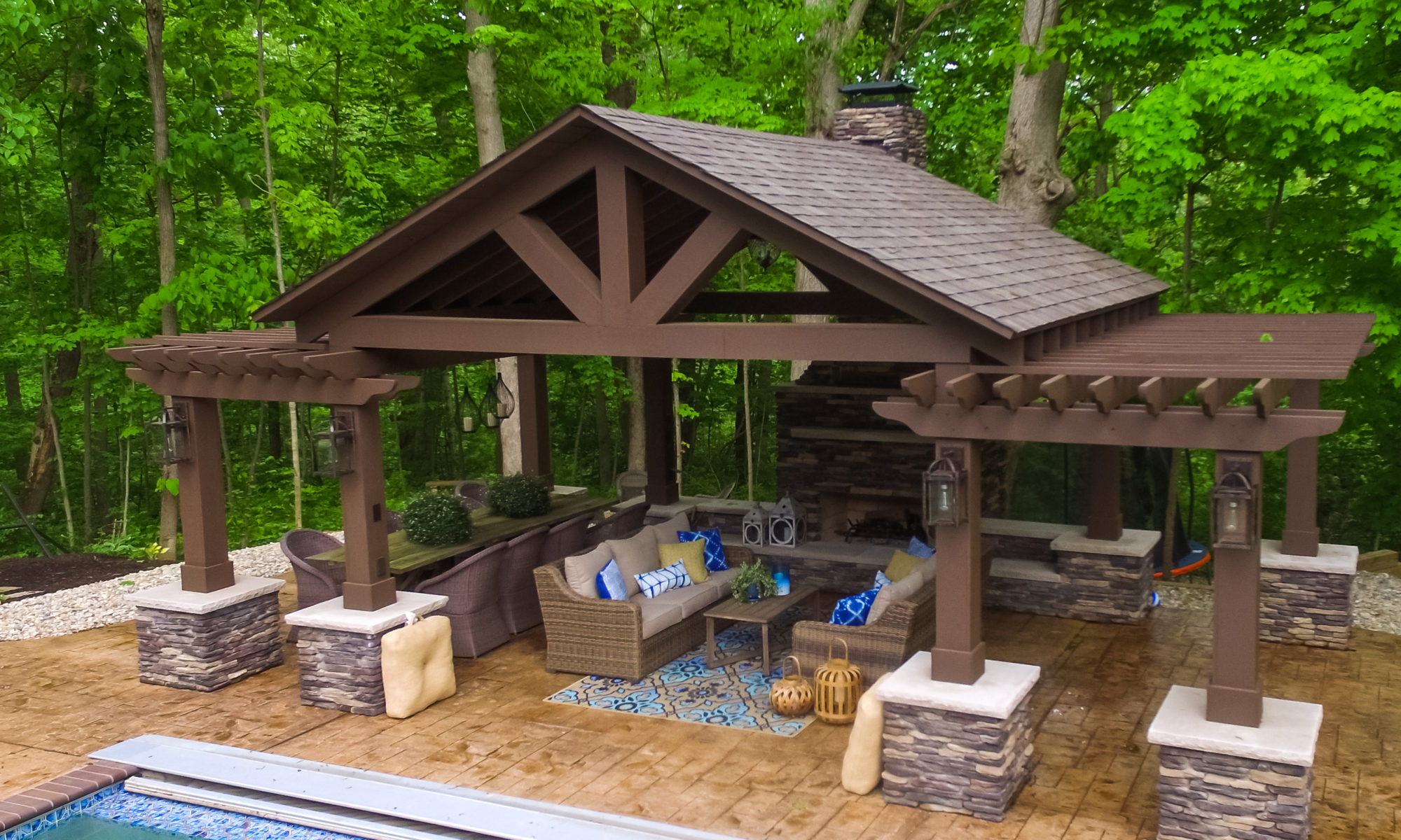 Precision Outdoors Avon patio & structure specialty built a-frame textured fireplace chimney pergola inspired structure decor additional seating raised sundeck tanning relaxation stamped concrete patio wrap around seating wall aesthetic style stone steps outdoor elements Avon indiana dream backyard pool