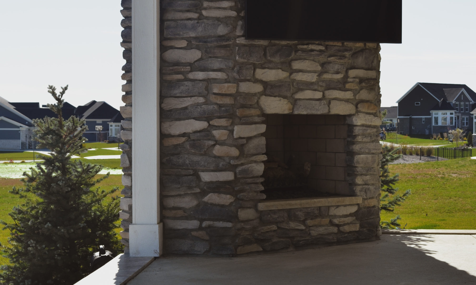 poolside pavillion paver patio pool fire fireplace stairs cover gray grey tanning deck graven plants trees flowers black
