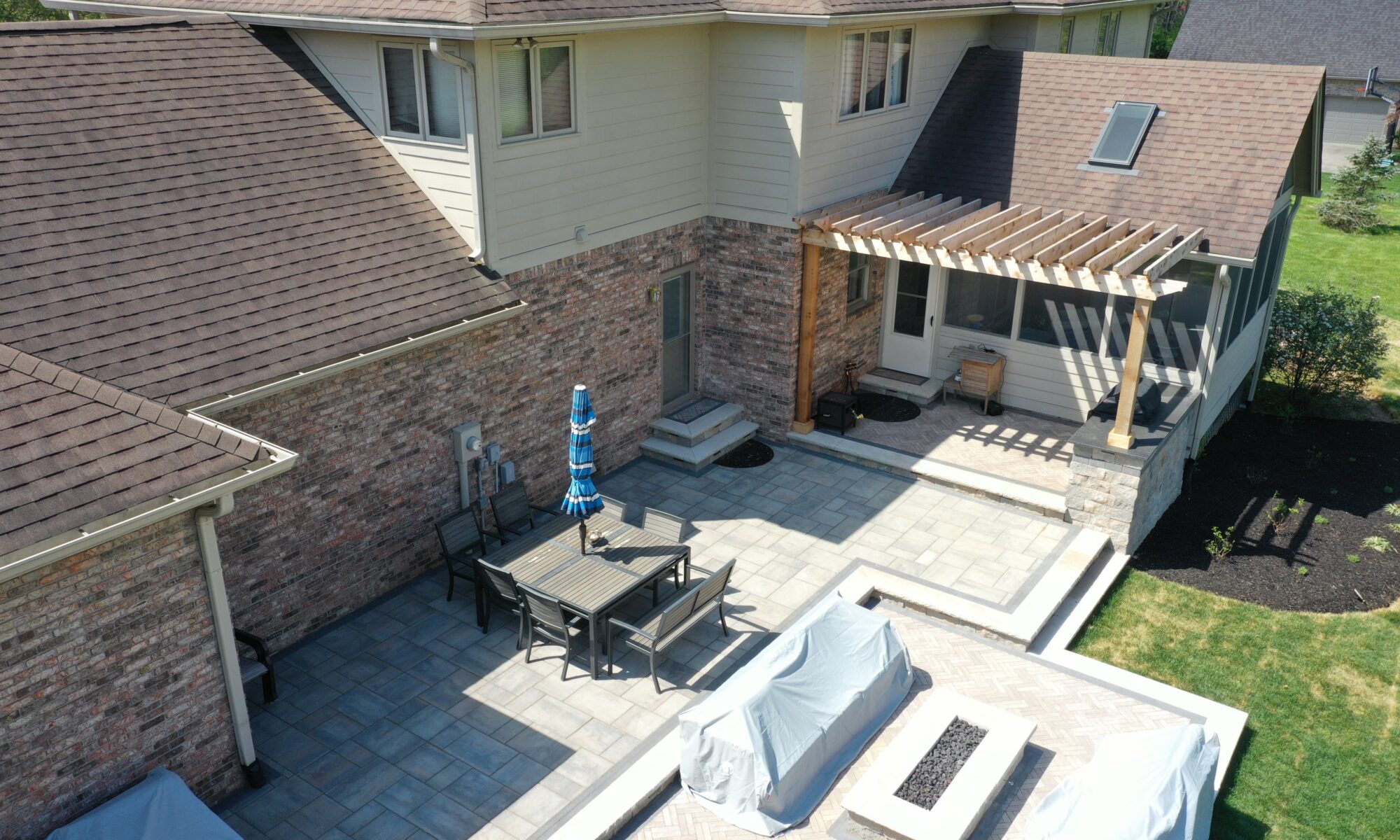 Precision Outdoors Terrace at Fox Run Zionsville Indiana Exterior design and build unilock estate wall river beacon hill flagstone alpine grey fossil unilock mattoni dark charcoal sable brown pergola outdoor kitchen gas fire pit outdoor dining area grill space several entertaining spaces large paver patio multilevel patio custom landscaping sod backyard goals mulch tree plants outdoor lighting