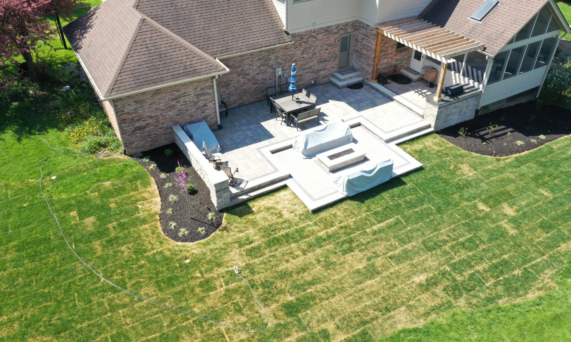 Precision Outdoors Terrace at Fox Run Zionsville Indiana Exterior design and build unilock estate wall river beacon hill flagstone alpine grey fossil unilock mattoni dark charcoal sable brown pergola outdoor kitchen gas fire pit outdoor dining area grill space several entertaining spaces large paver patio multilevel patio custom landscaping sod backyard goals mulch tree plants outdoor lighting