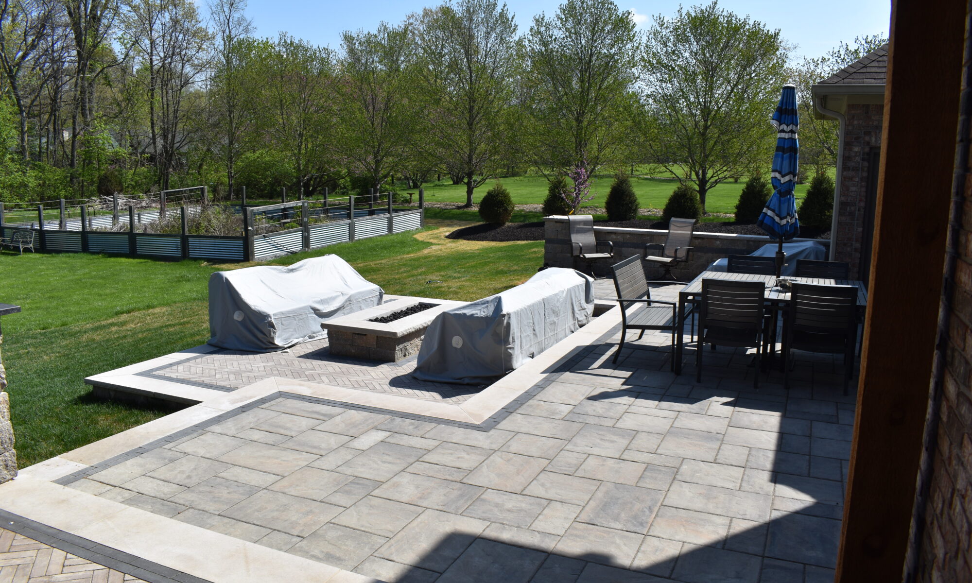 Precision Outdoors Terrace at Fox Run Zionsville Indiana Exterior design and build unilock estate wall river beacon hill flagstone alpine grey fossil unilock mattoni dark charcoal sable brown pergola outdoor kitchen gas fire pit outdoor dining area grill space several entertaining spaces large paver patio multilevel patio custom landscaping sod backyard goals mulch tree plants outdoor lighting