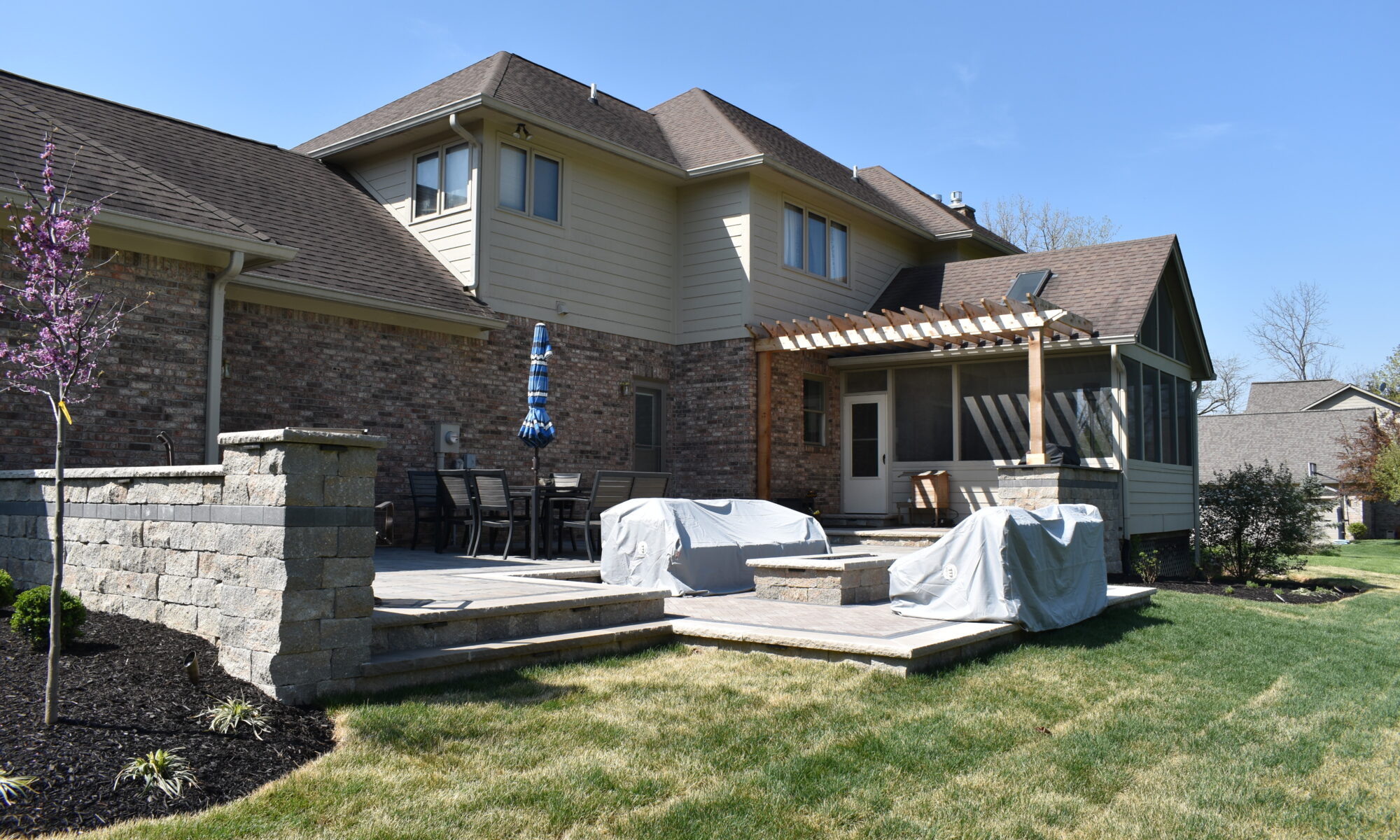 Precision Outdoors Terrace at Fox Run Zionsville Indiana Exterior design and build unilock estate wall river beacon hill flagstone alpine grey fossil unilock mattoni dark charcoal sable brown pergola outdoor kitchen gas fire pit outdoor dining area grill space several entertaining spaces large paver patio multilevel patio custom landscaping sod backyard goals mulch tree plants outdoor lighting