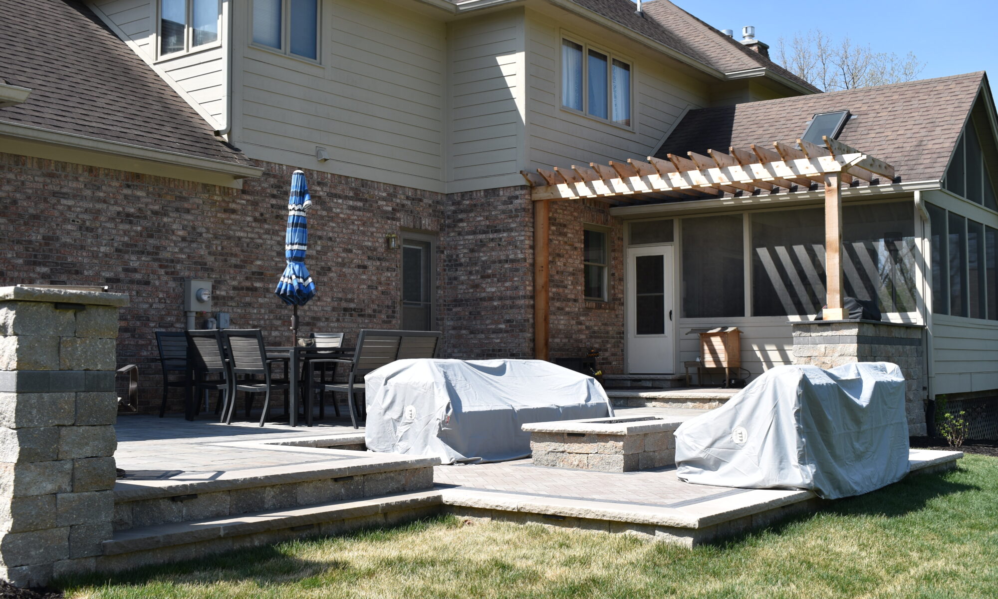 Precision Outdoors Terrace at Fox Run Zionsville Indiana Exterior design and build unilock estate wall river beacon hill flagstone alpine grey fossil unilock mattoni dark charcoal sable brown pergola outdoor kitchen gas fire pit outdoor dining area grill space several entertaining spaces large paver patio multilevel patio custom landscaping sod backyard goals mulch tree plants outdoor lighting