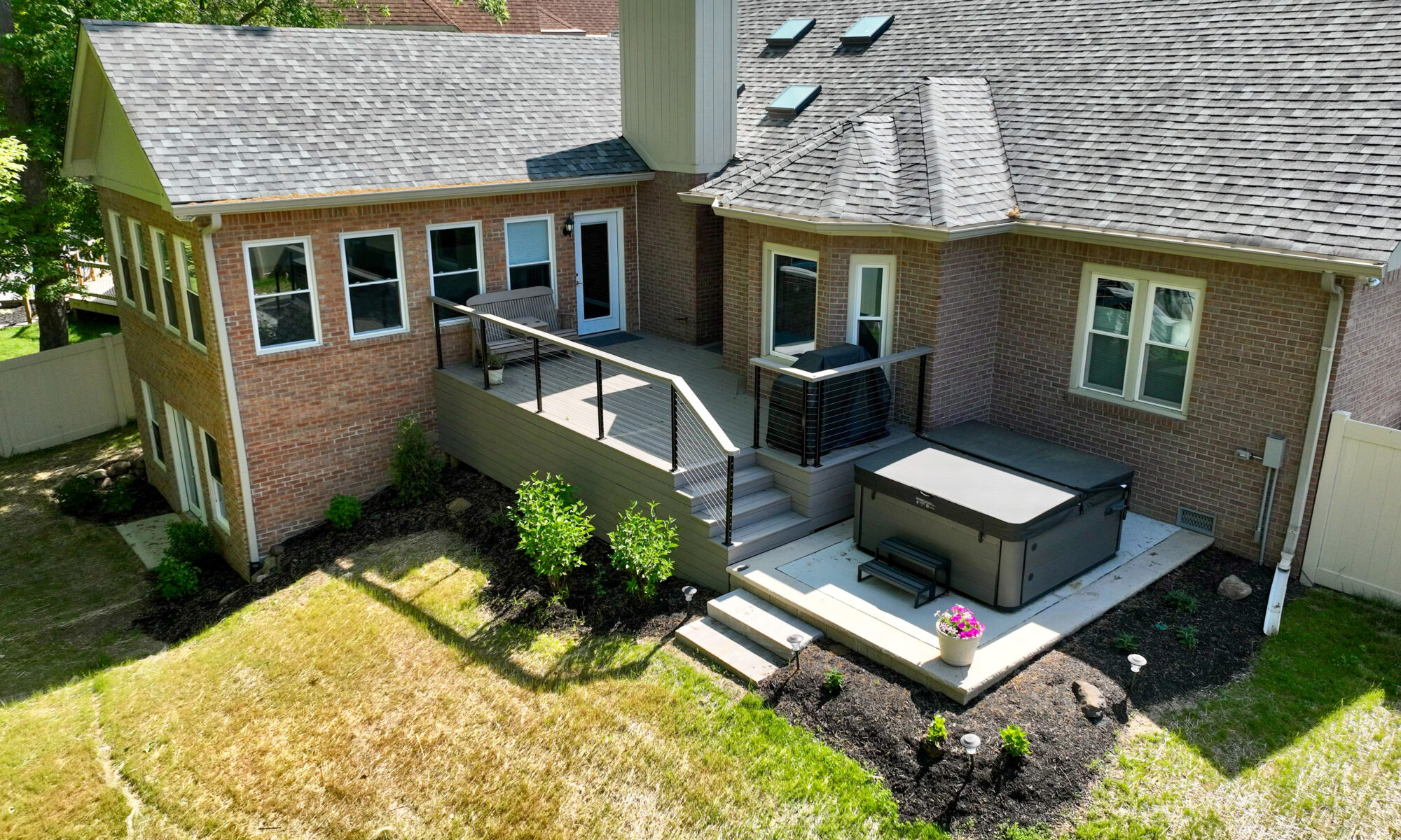 Precision outdoors Indianapolis Indiana two story two-story room addition four season room trex composite deck decking outdoor custom bookshelves custom carpentry lighted stairs lit stairway trex Select Composite Deck Pebble Gray Rocky Harbor accent color Modern cable railing surrounding deck Large outdoor dining space Custom bookshelves Custom landscaping backyard goals upgrade Basement bathroom home office hidden deck storage