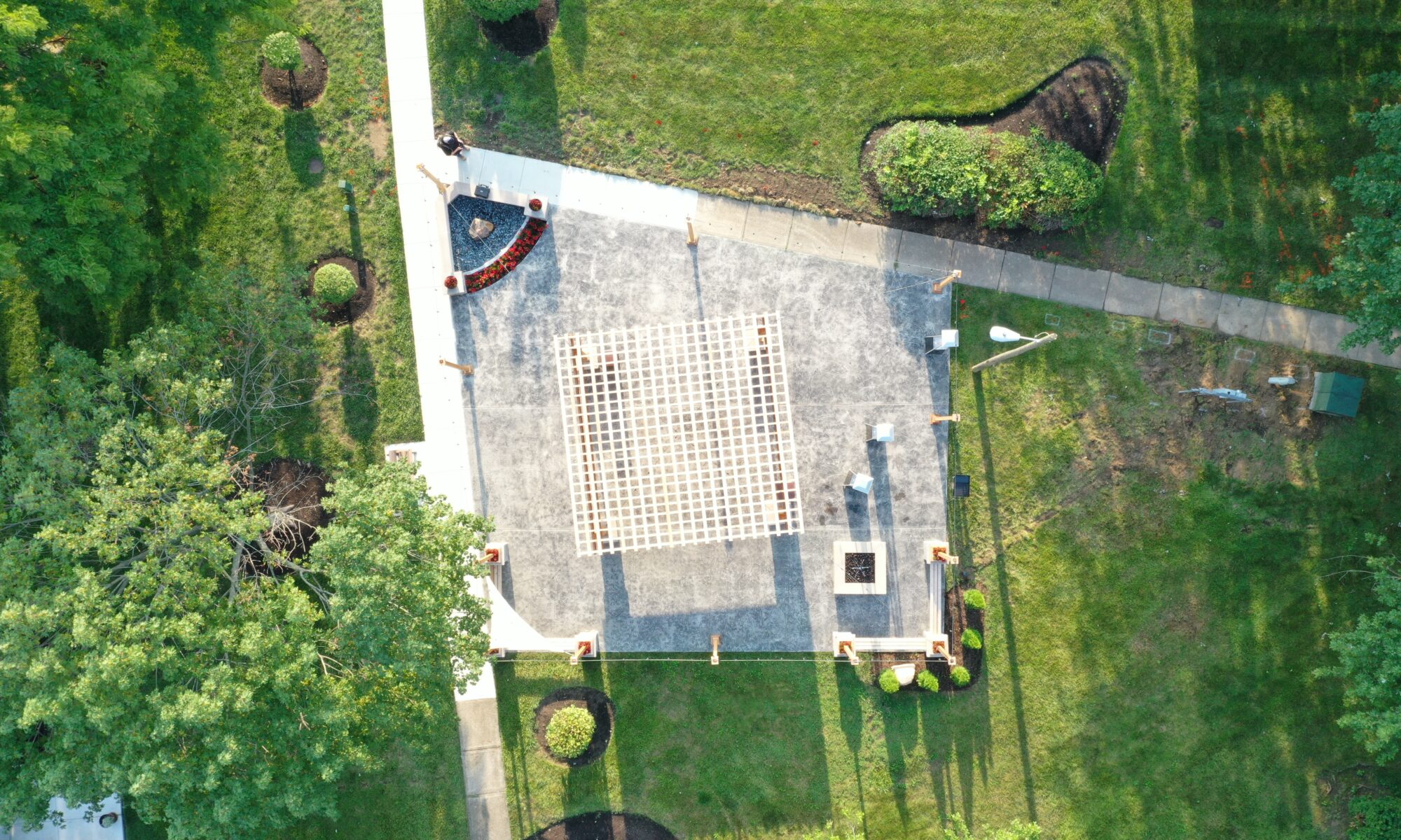 Precision Outdoors Greenwood Indiana Smock Courtyard senior living community large pergola arborvitae bubbling boulder water feature fountain propane fire pit seating corner propane heaters heat source custom landscaping flowers mulch night lighting string lights grill propane heaters flowers shared living space exterior design and build perfectly manicured turf