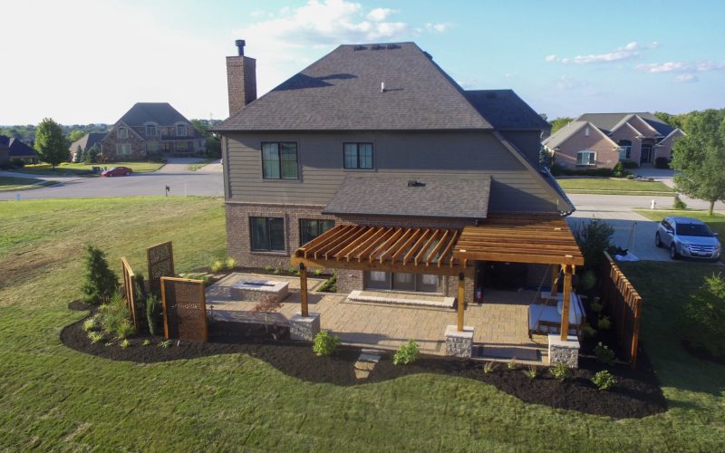 Precision Outdoors Kensington Oasis rough sawn cedar pergola black hardware decorative sunscreens outdoor gas firepit fire pit ample dining seating custom paver patio swinging daybed tech bloc semma wall sandlewood charcoal accent Carmel indiana backyard goals landscaping privacy
